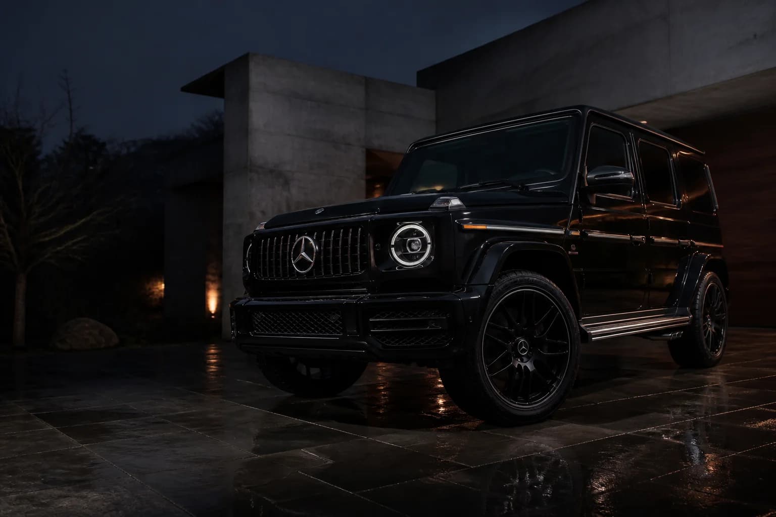 Mercedes Clase G negro recién detallado ante una vivienda contemporánea al anochecer